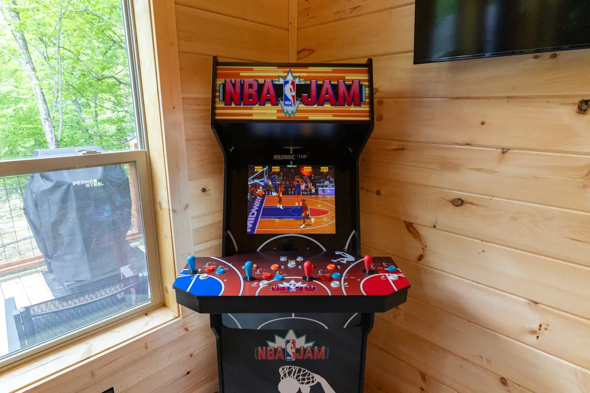 An interior setting featuring a classic arcade game positioned beside a window, inviting competitive gaming sessions and nostalgic fun for groups of friends.